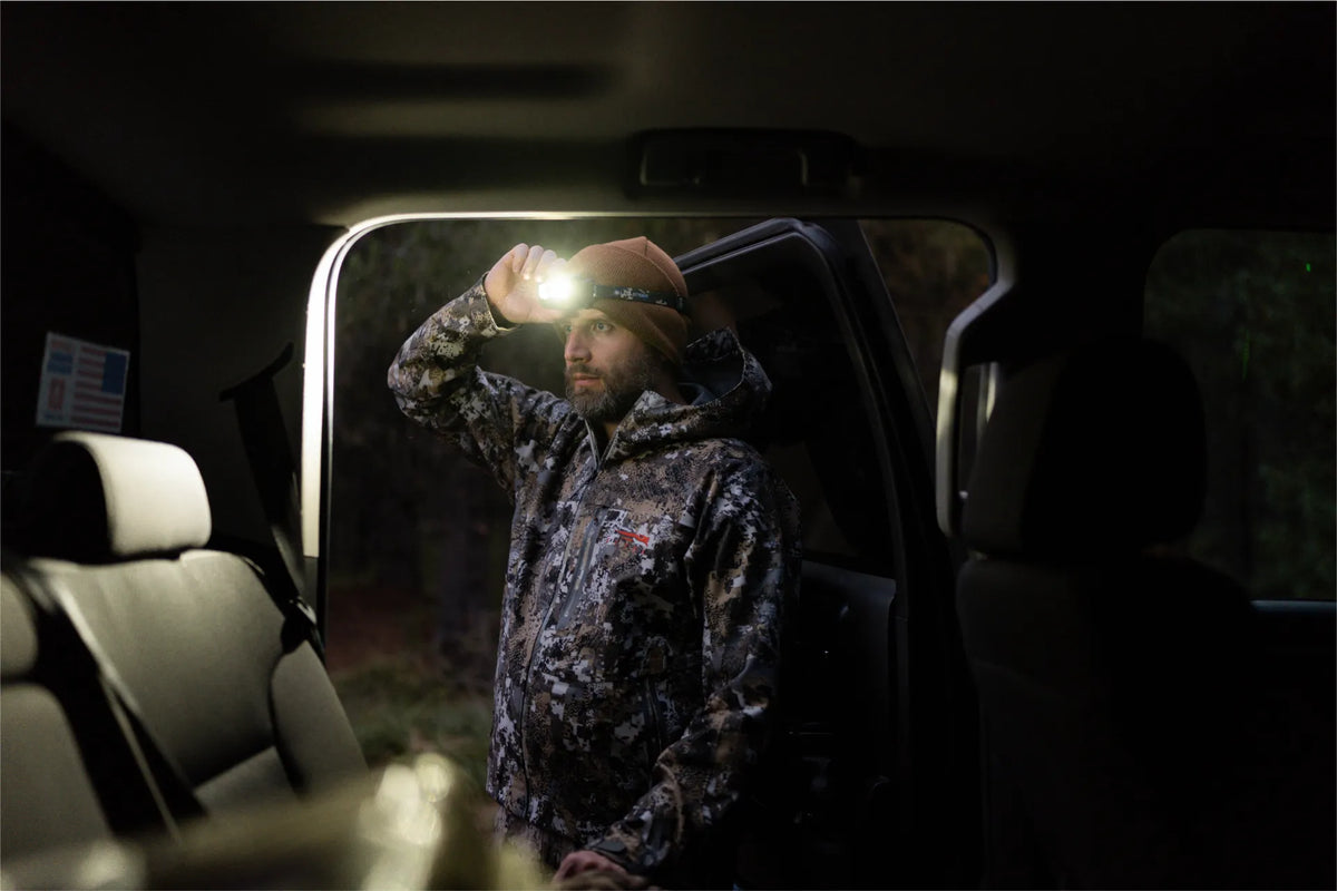 Hunter at his truck before sunrise wearing a hands-free headlamp
