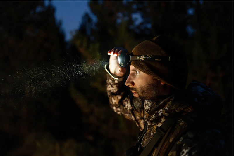 Hunter adjusting the HF8R Core RGB in the dark woods